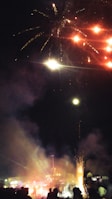 Bright fireworks illuminating a crowd gathered for a celebration.