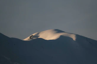 A serene snowy mountain peak bathed in soft morning light, evoking calm and exclusivity.