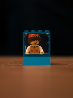 A smiling customer holding a boxed retired LEGO set at checkout.