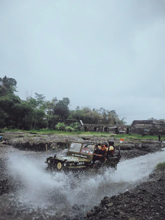a jeep driving through a river filled with water