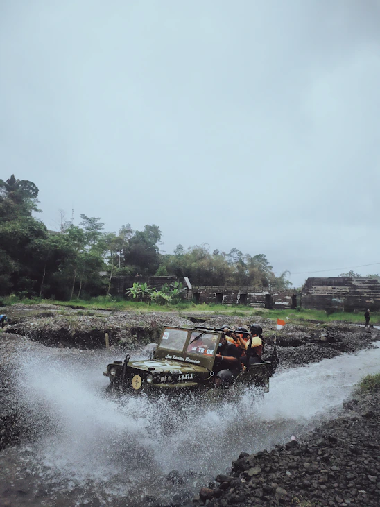 a jeep driving through a river filled with water