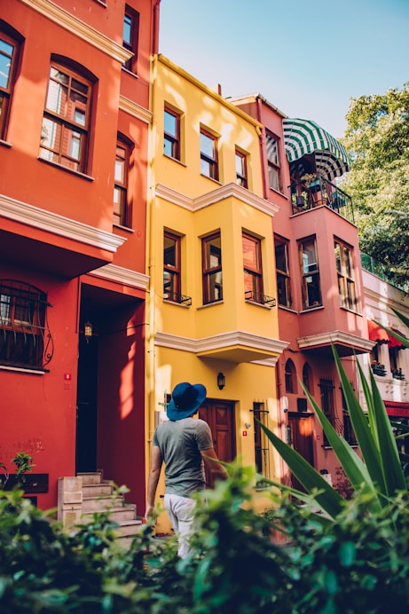 a man walking in front of a multi - colored building
