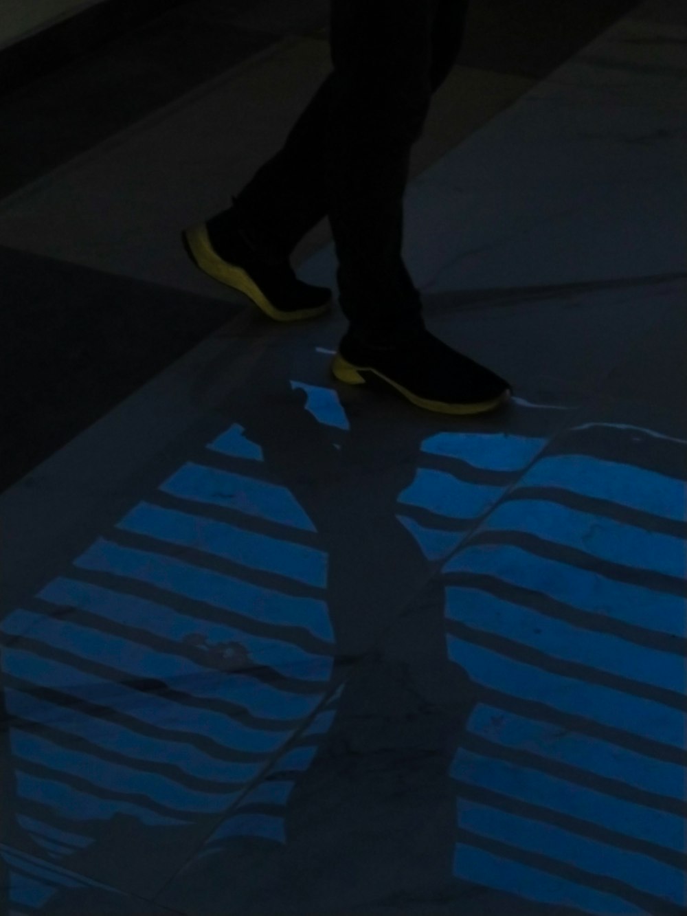 a person walking across a cross walk with their shoes on