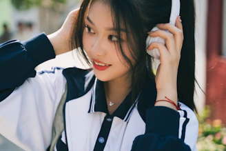 A comforting scene of a person smiling gently while listening through headphones.