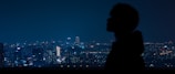 Nighttime city skyline with a model silhouetted against glowing lights, showcasing Lumina Apparel’s modern vibe.