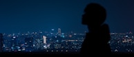 Evening city skyline with a model in Lumina Apparel silhouetted against the glowing lights.