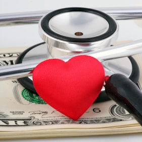 a stethoscope and a heart on top of money