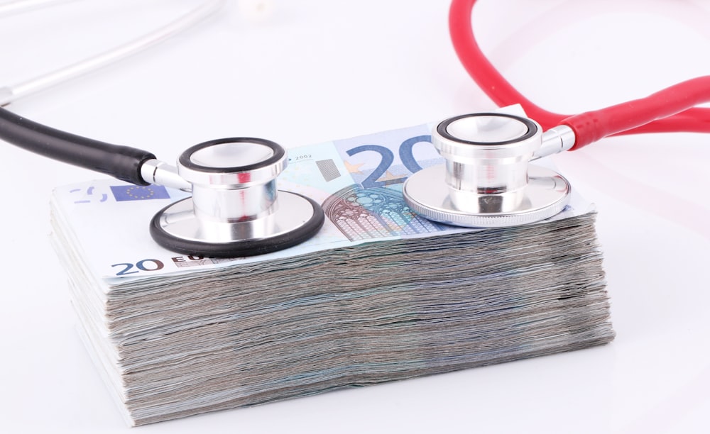 a pile of money with a stethoscope on top of it