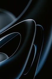 Dark-themed album cover with abstract futuristic shapes and glowing accents.