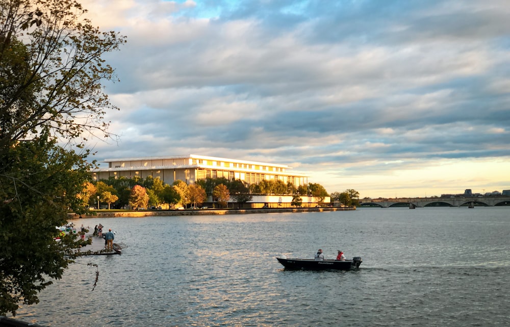 a boat on a body of water with a building in the background