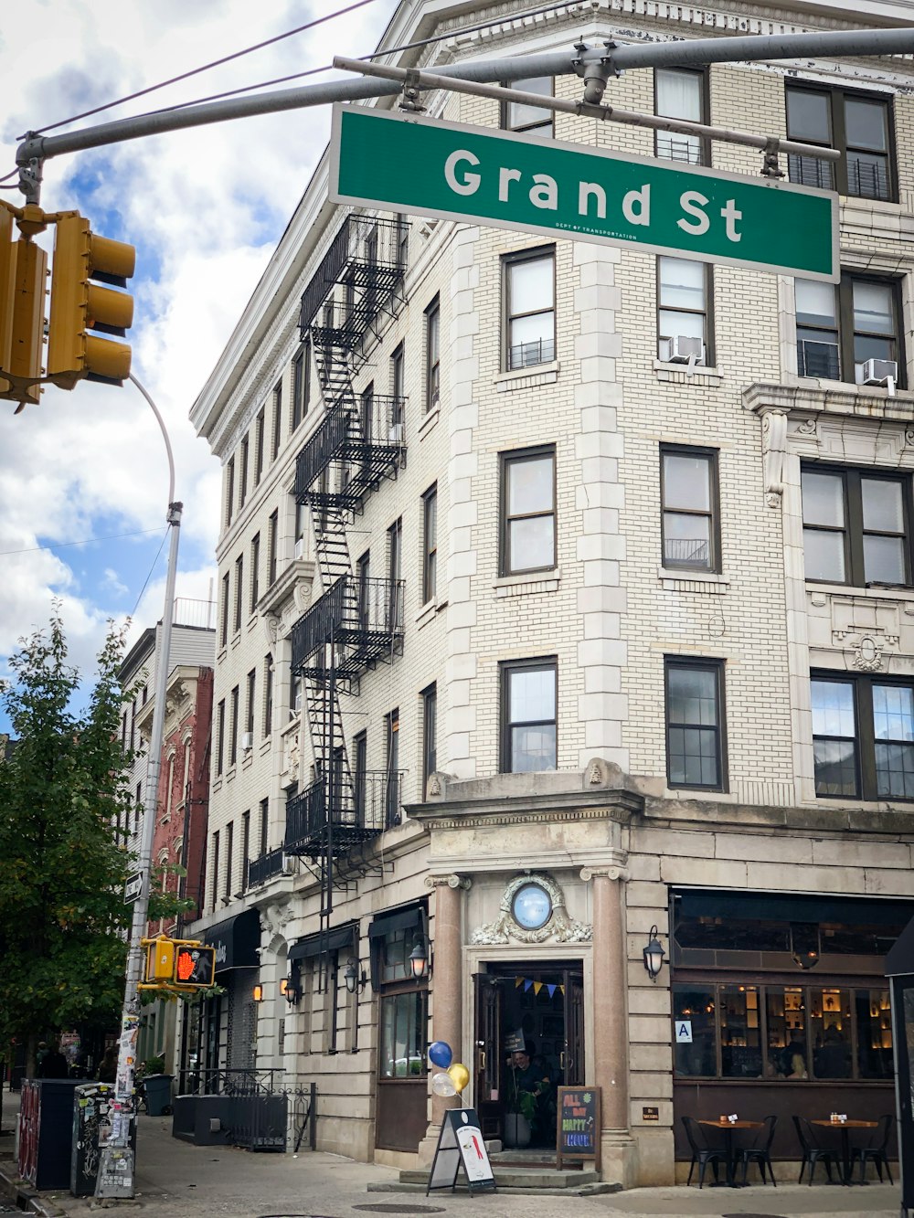 a street sign that reads grand st in front of a building