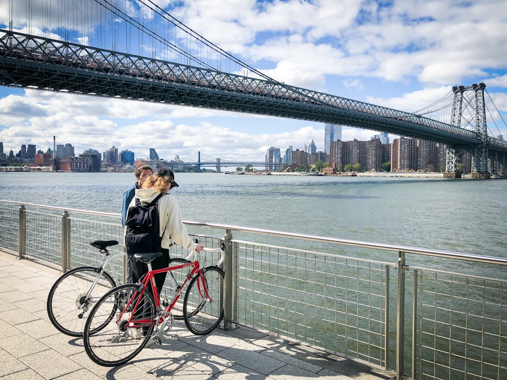 a man and a woman standing next to a red bike