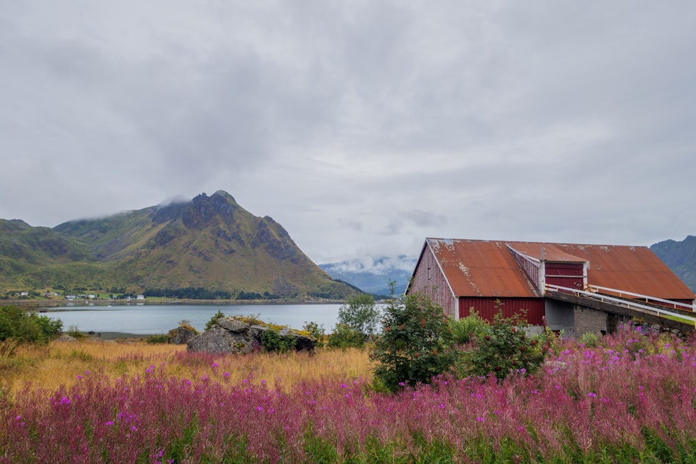 a house in the middle of a field with mountains in the background