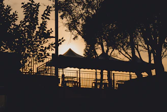 Sunset view over the retreat grounds with tents and trees silhouetted against the sky.