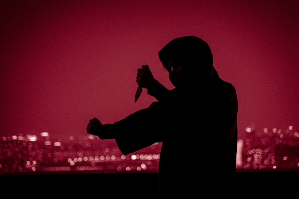 A dynamic character portrait of a teen idol assassin wielding dual daggers, set against a neon-lit cityscape.