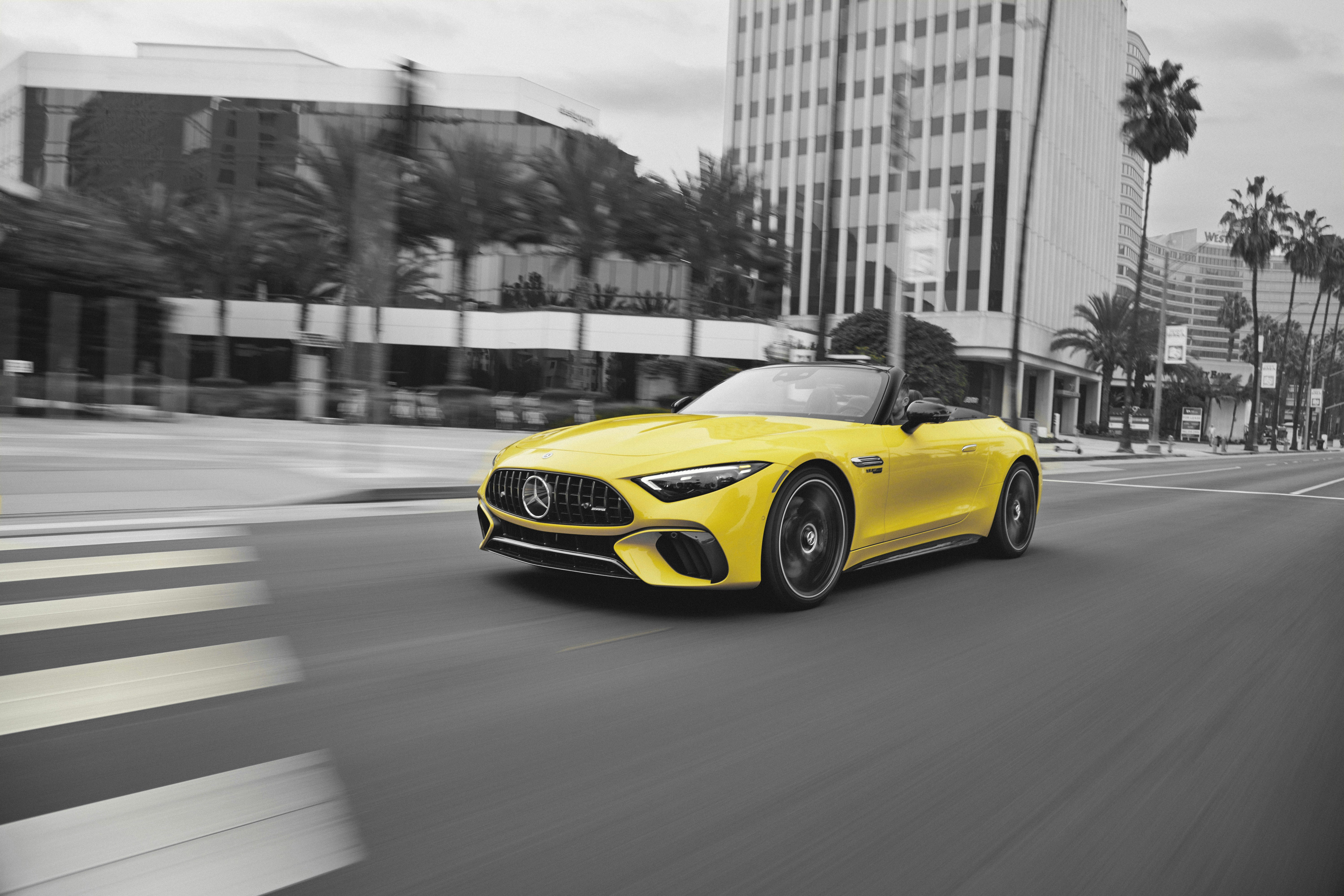 a yellow sports car driving down a city street