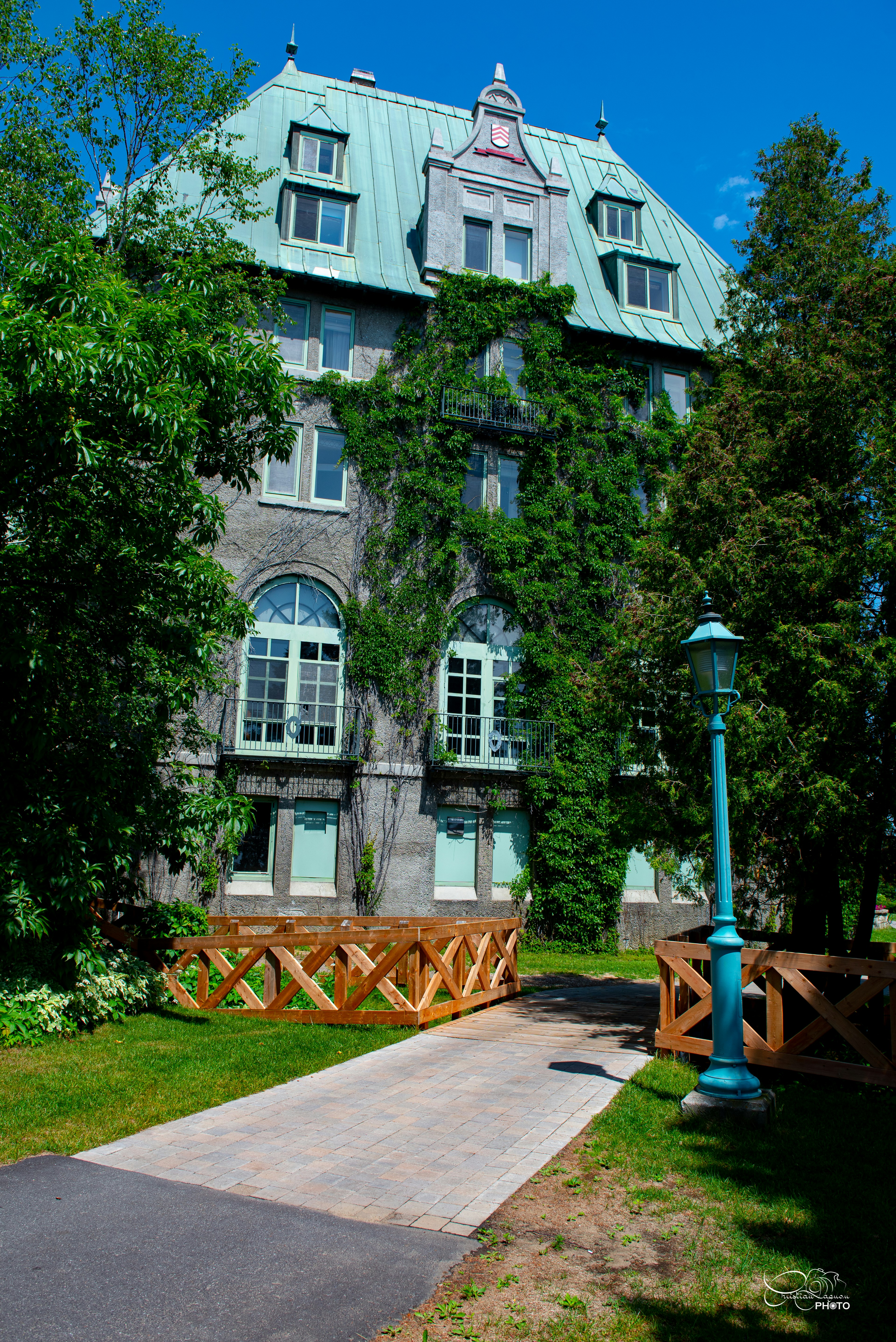 a large building with a green roof and a blue lamp post
