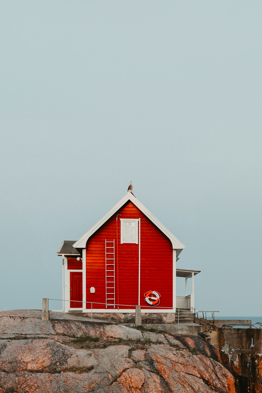 a red house sitting on top of a cliff