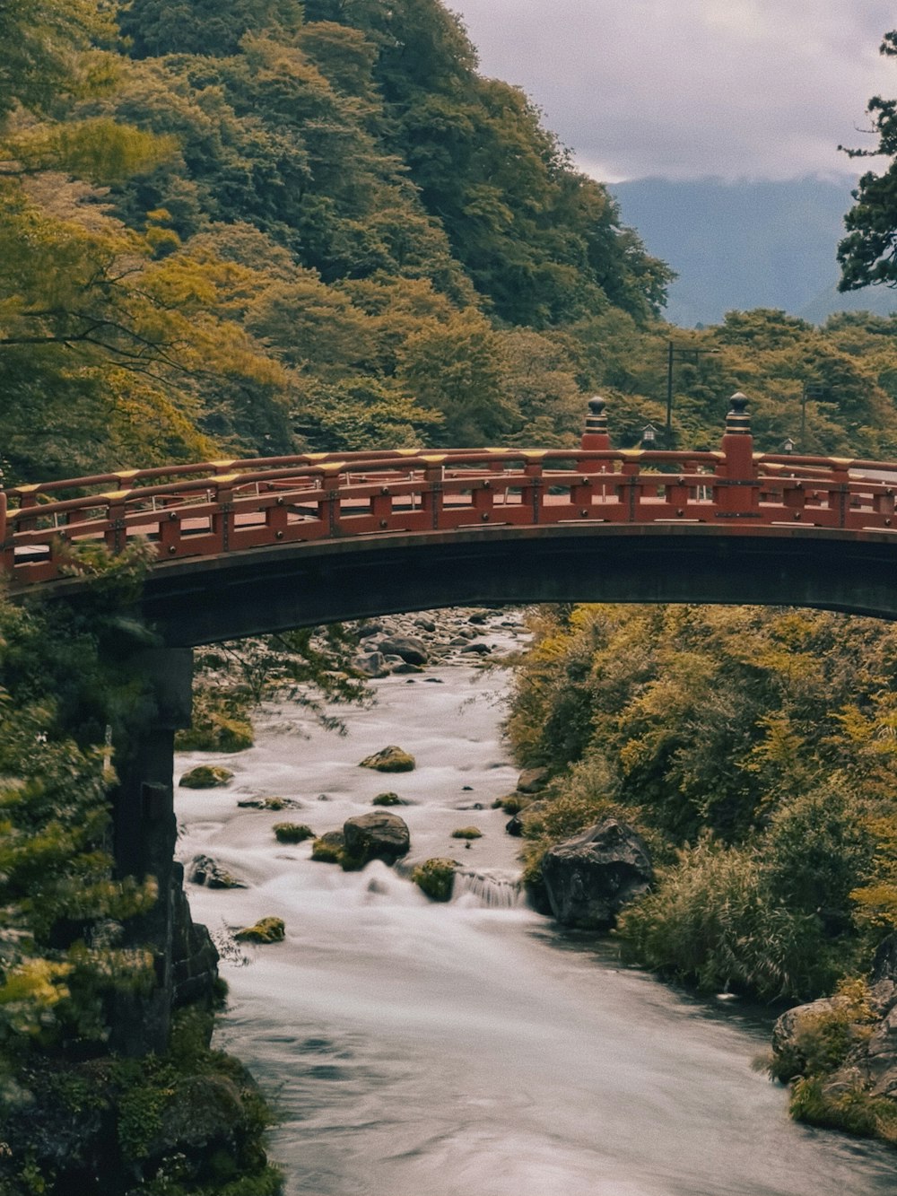 a bridge over a river with a red railing