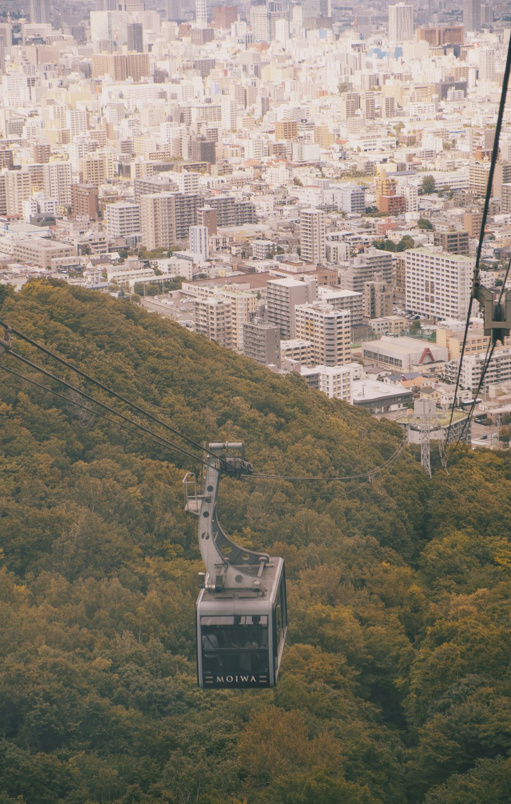 a cable car going up a hill with a city in the background