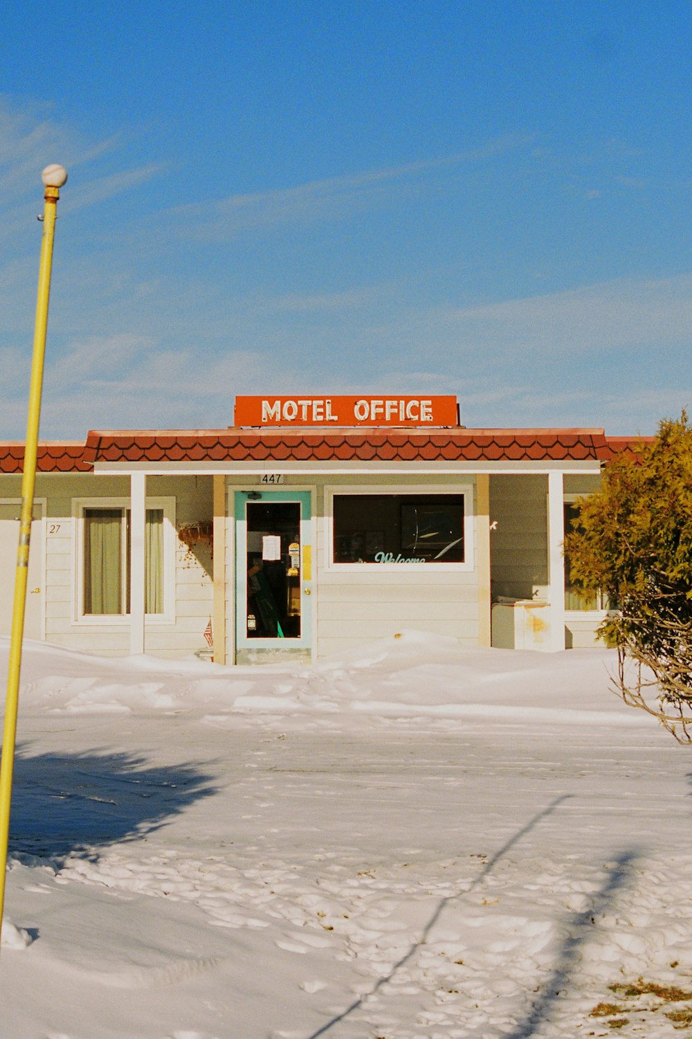 a motel building with a yellow pole in front of it