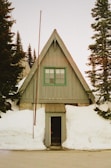 Front view of a small rustic cabin surrounded by tall pine trees in Norway, Maine.
