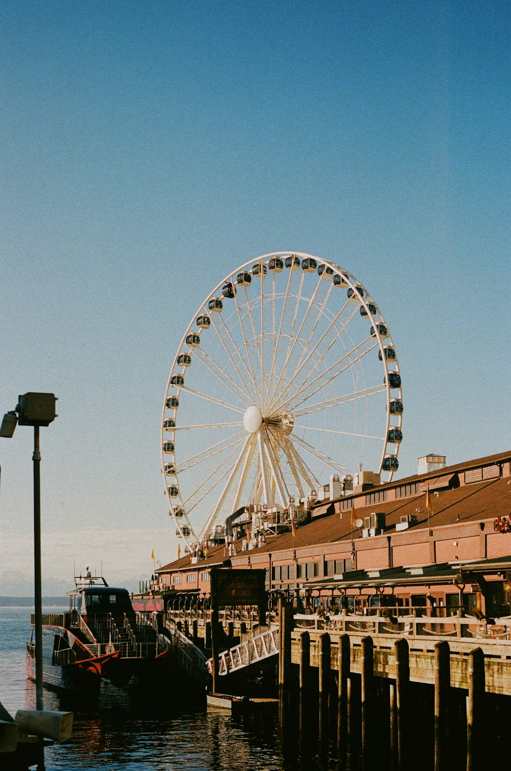a large ferris wheel sitting next to a pier