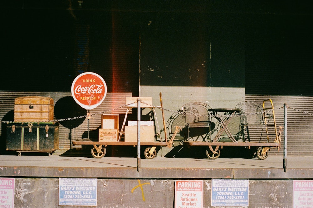 a train cart sitting next to a building with a coca cola sign on it