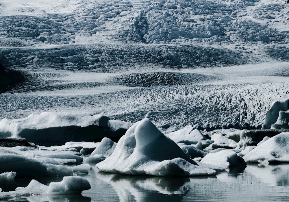 a group of icebergs floating on top of a body of water