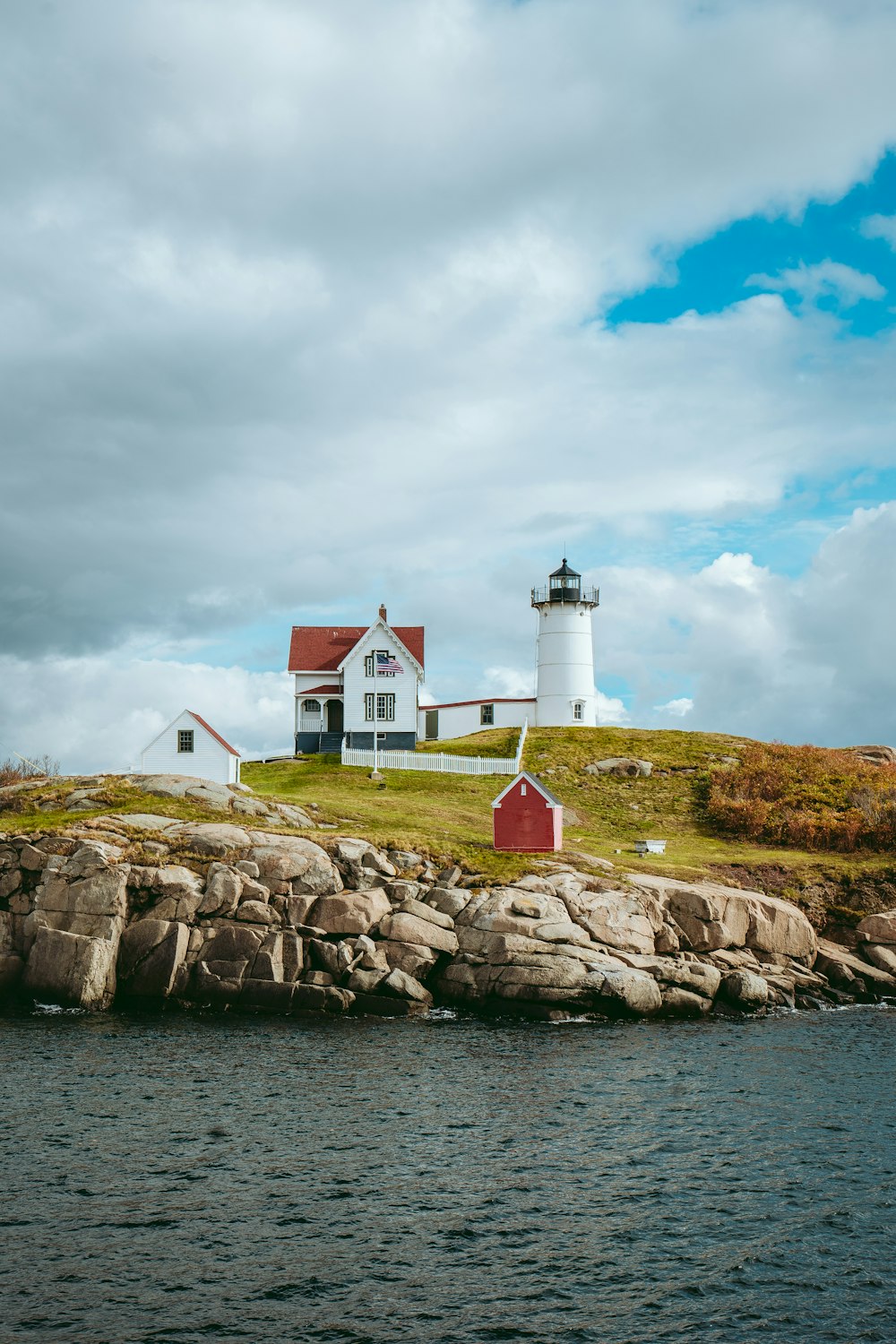 a red and white lighthouse on a rocky island