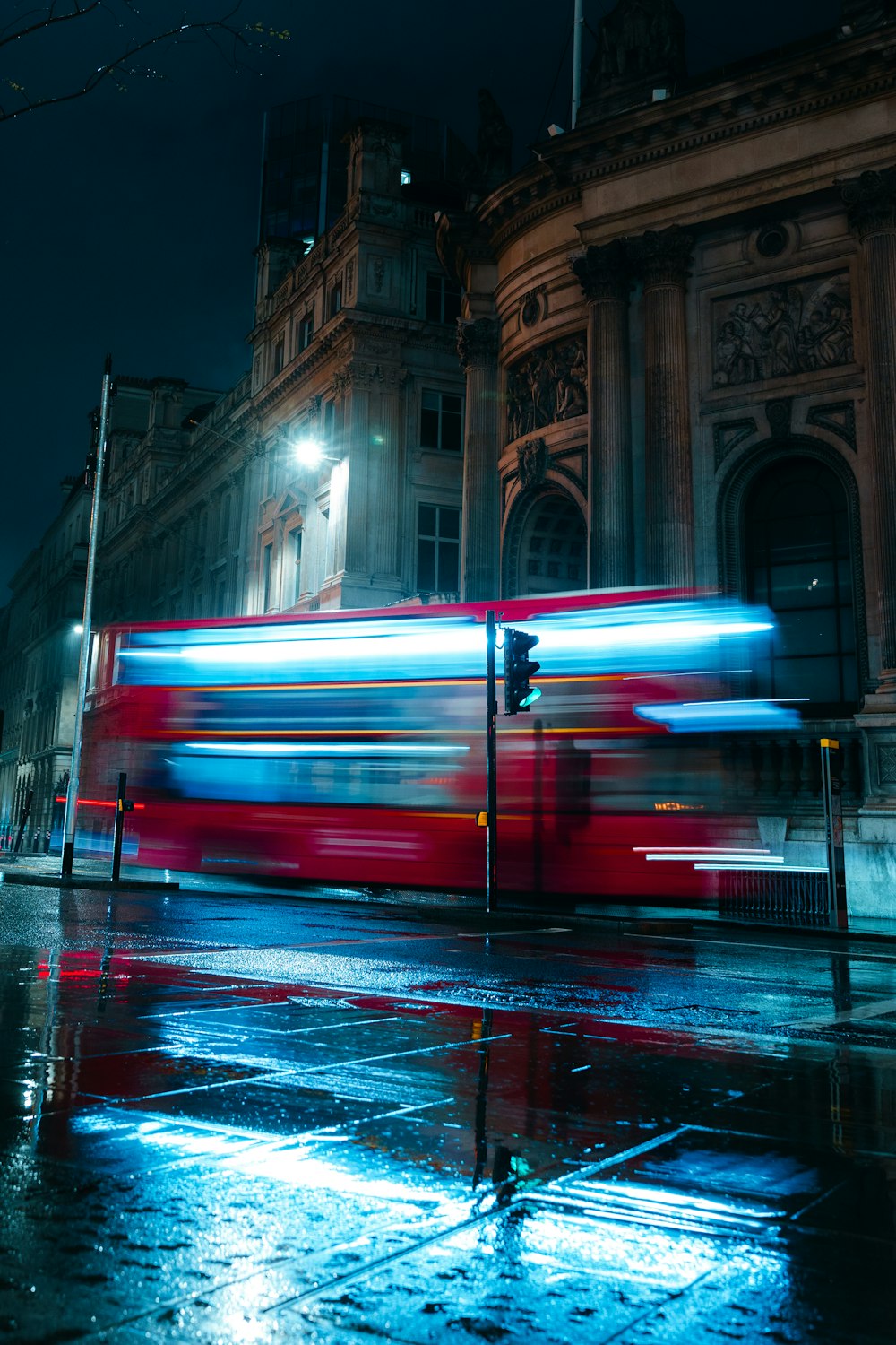 a double decker bus driving down a street at night