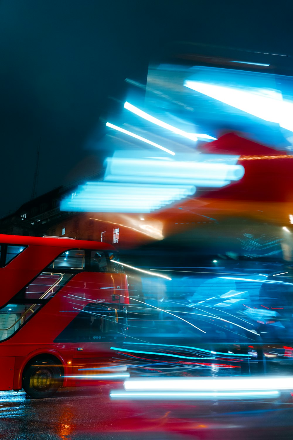 a red double decker bus driving down a street