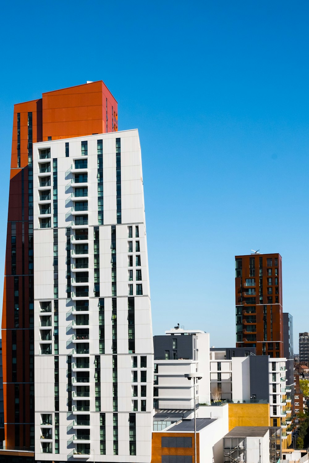 a tall white and orange building in a city