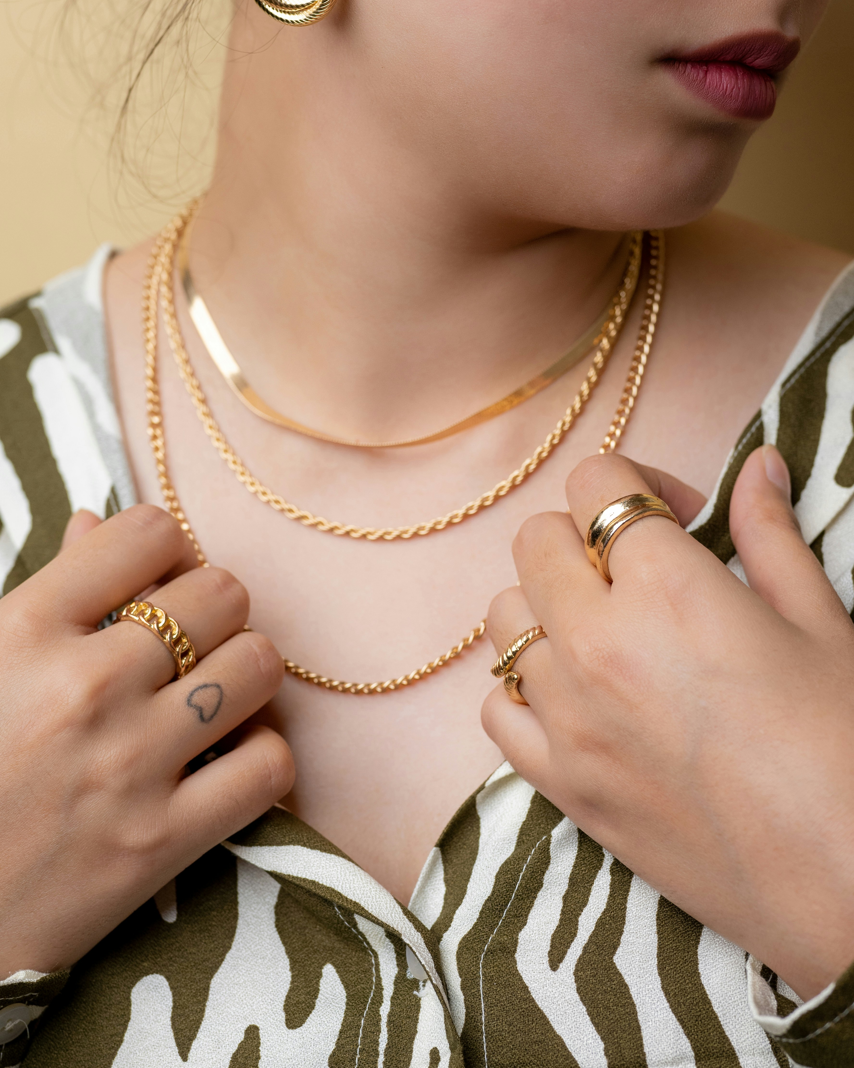 a woman wearing two rings and a necklace