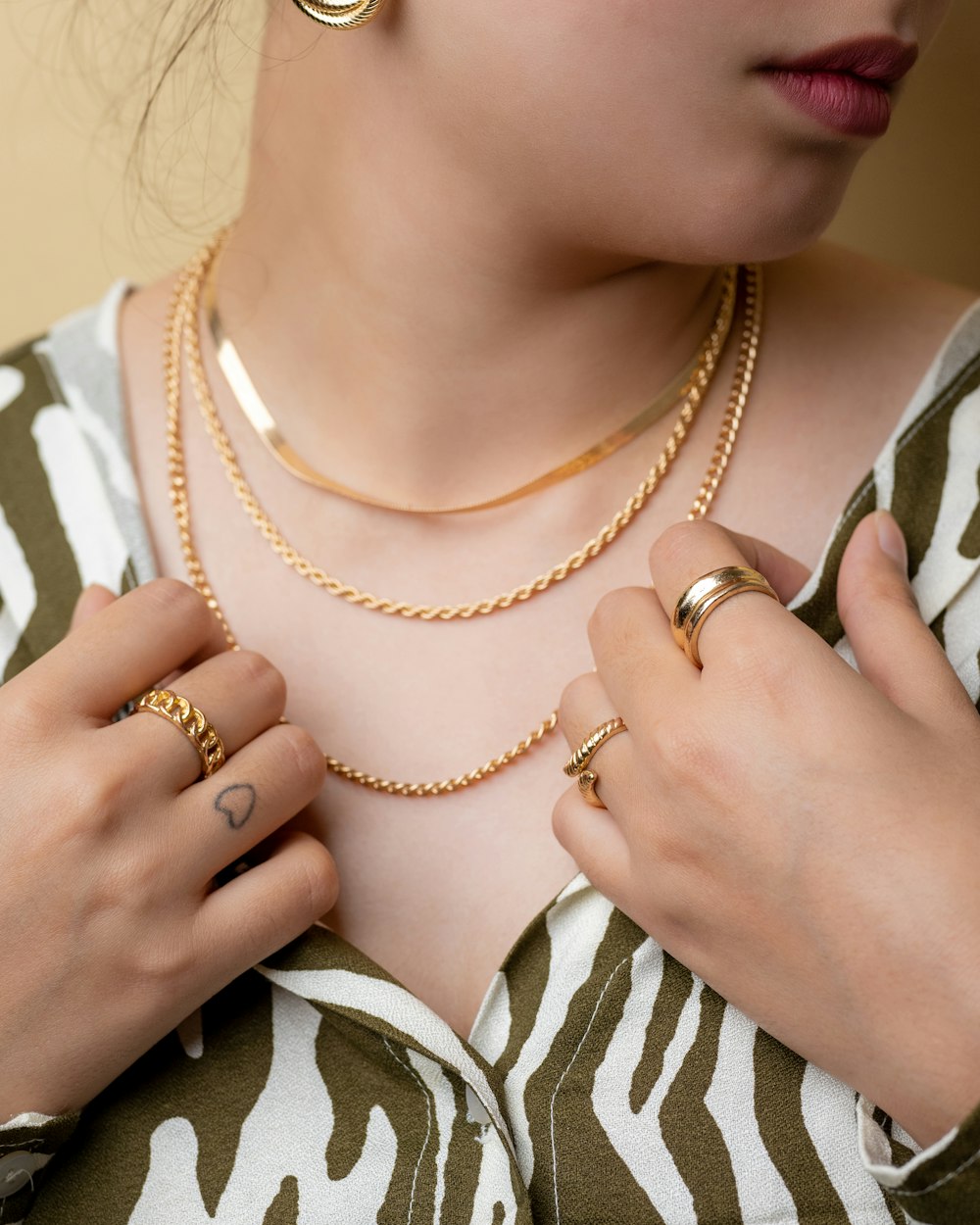 a woman wearing two rings and a necklace