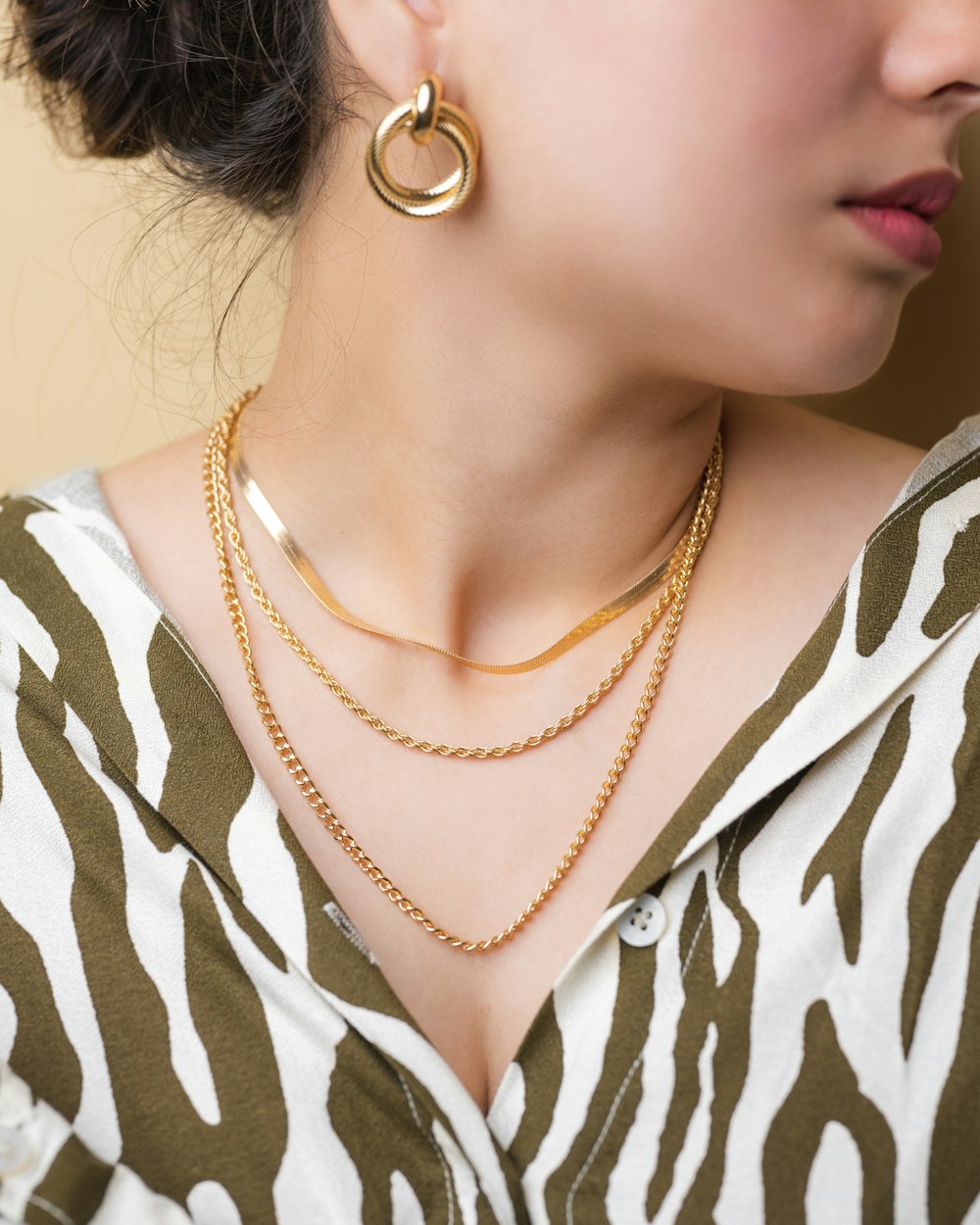 a woman wearing a zebra print shirt and a gold necklace
