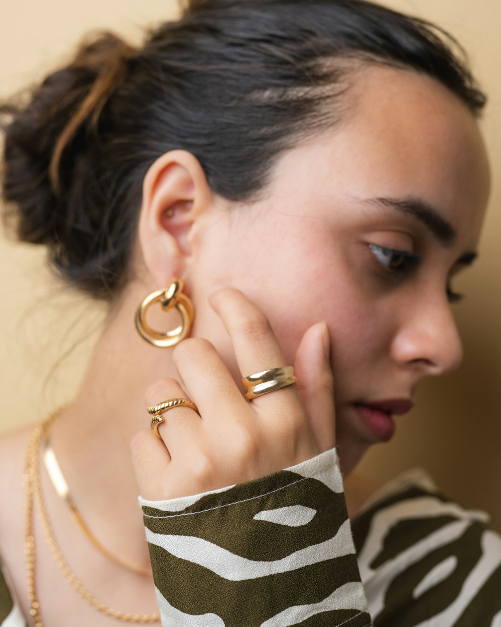 a woman wearing a pair of gold rings
