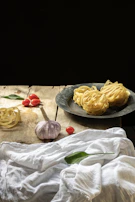 A rustic wooden table with ingredients laid out for a quick pasta recipe.