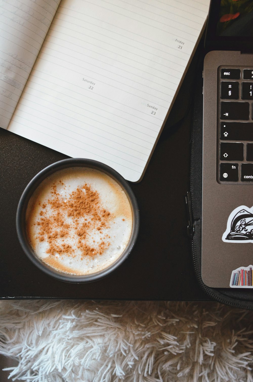 a cup of coffee next to a laptop computer