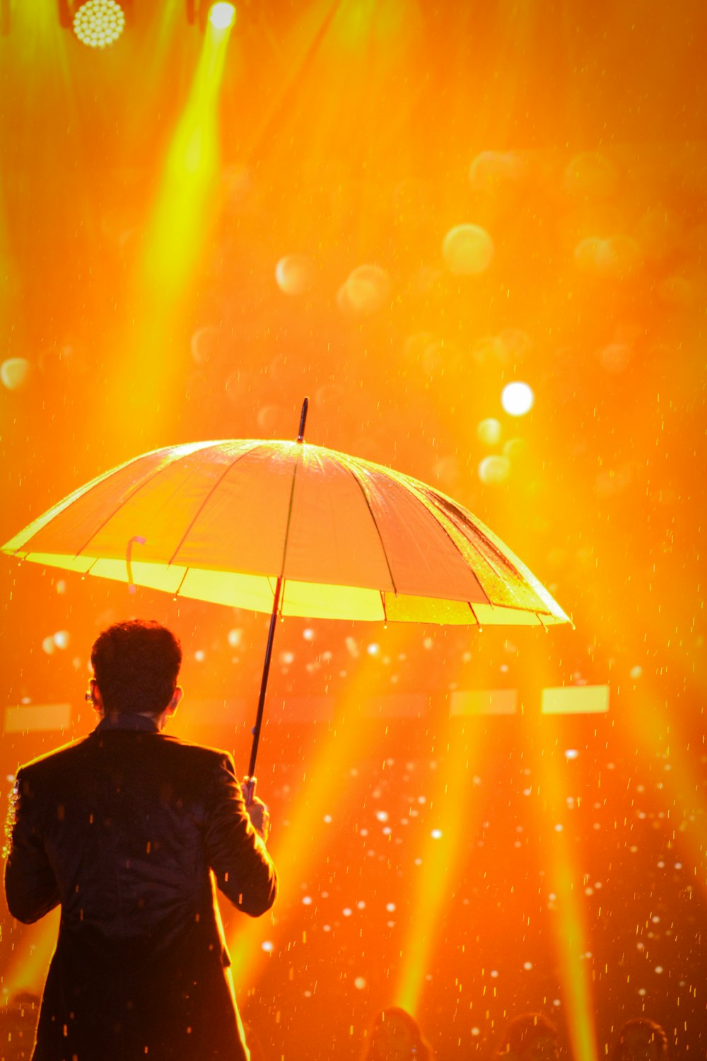 a man standing under an umbrella in the rain