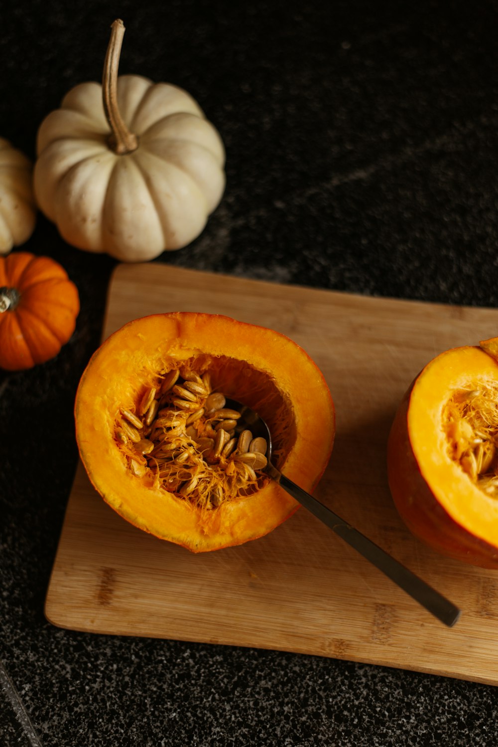 a couple of pumpkins sitting on top of a wooden cutting board