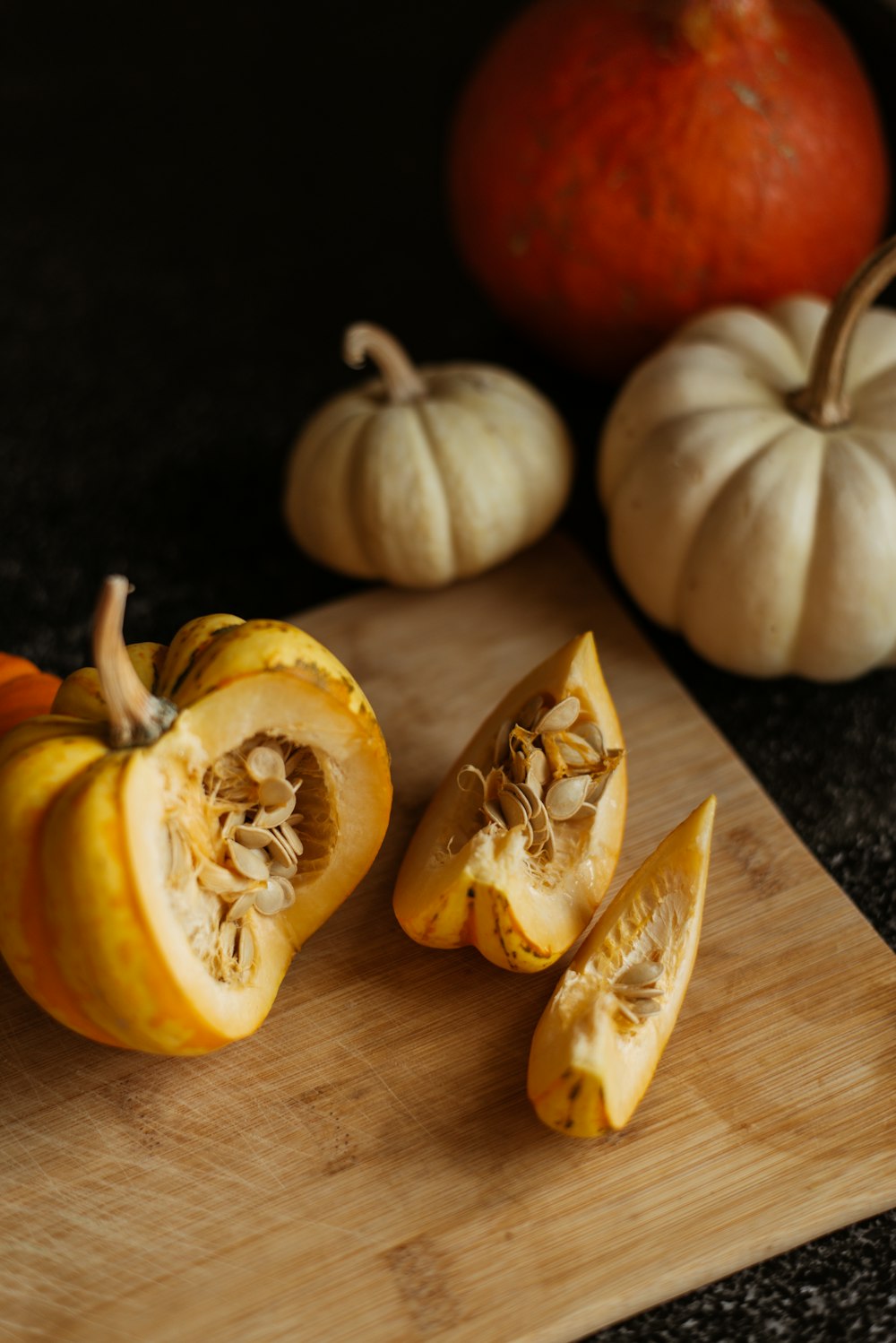 a wooden cutting board topped with cut up pumpkins