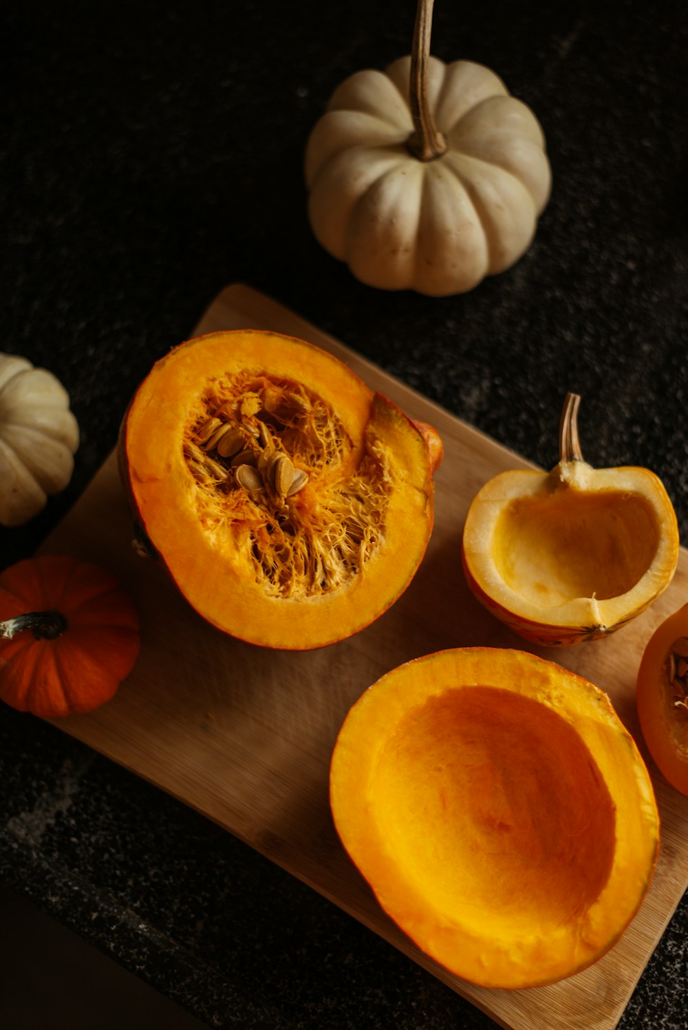 a cutting board topped with a cut in half pumpkin