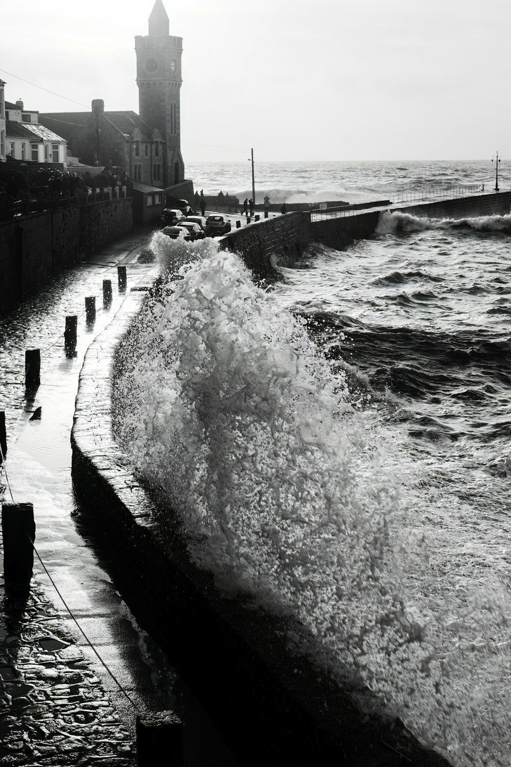 a black and white photo of waves crashing on the shore