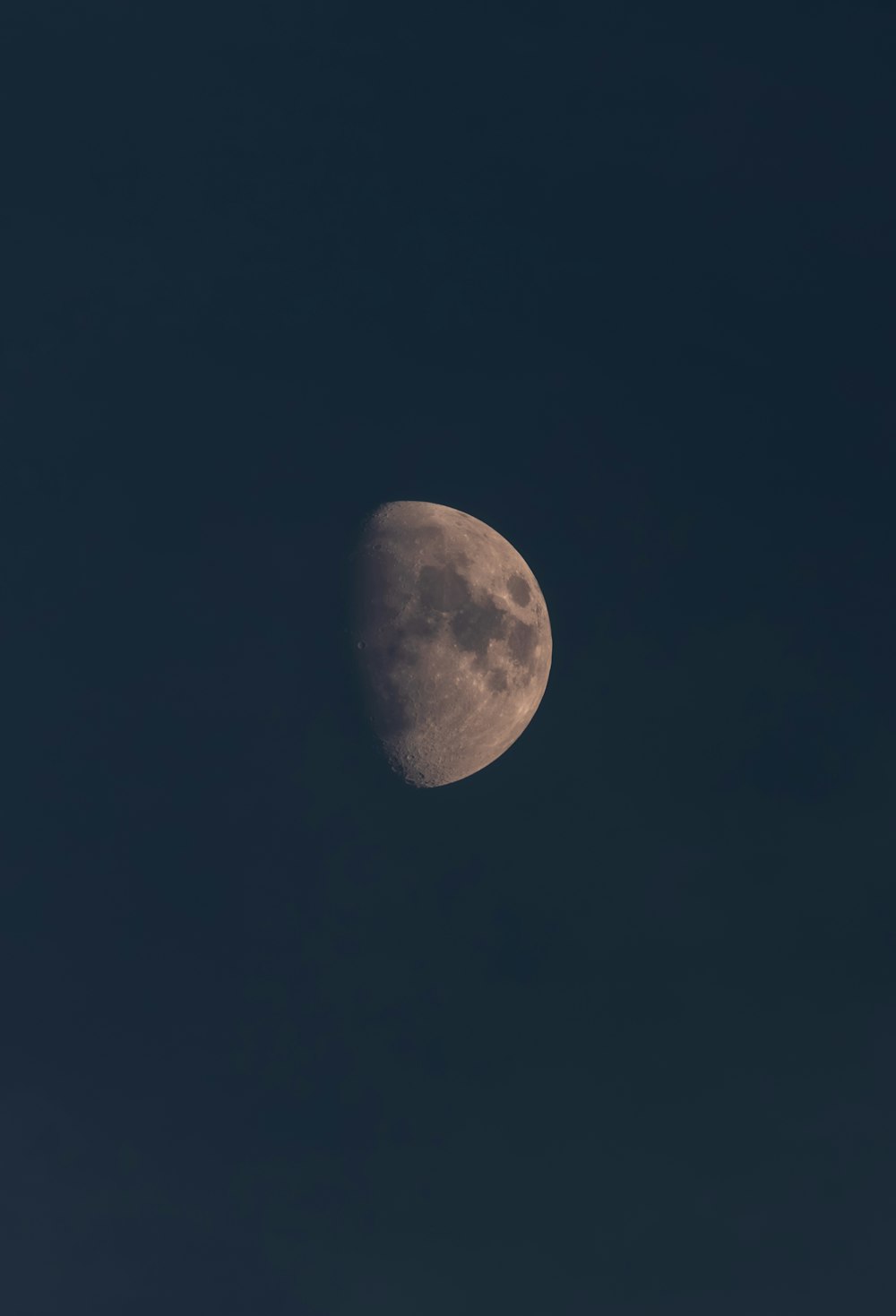 a half moon in a dark blue sky