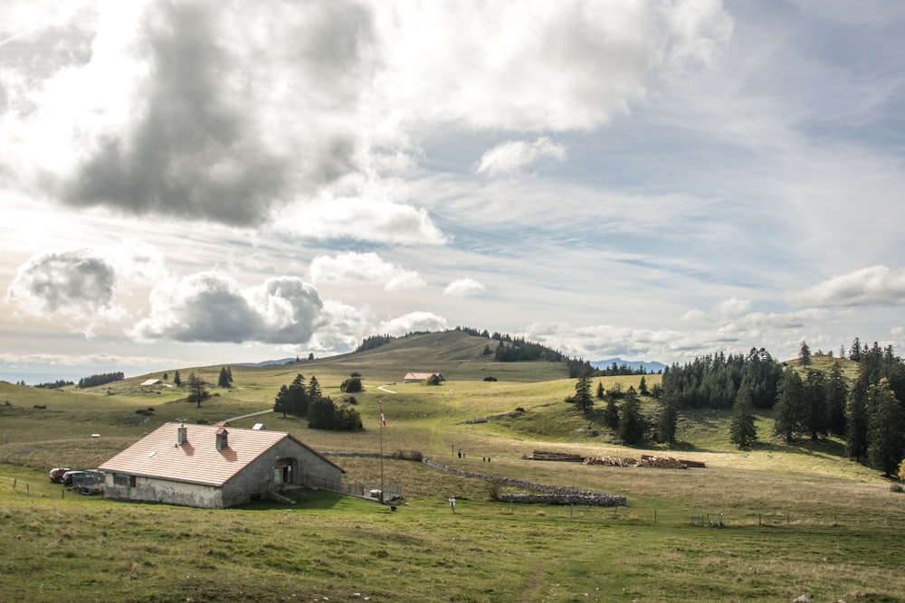 une maison dans un champ avec une montagne en arrière-plan