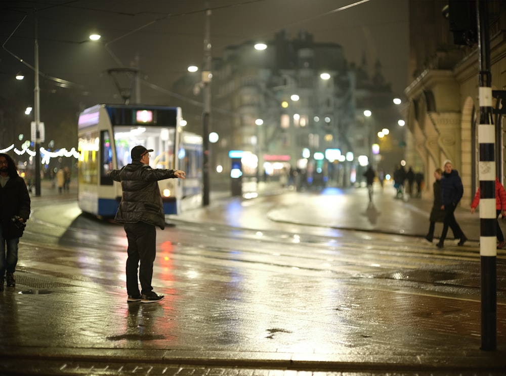 a man standing on a street corner in the rain