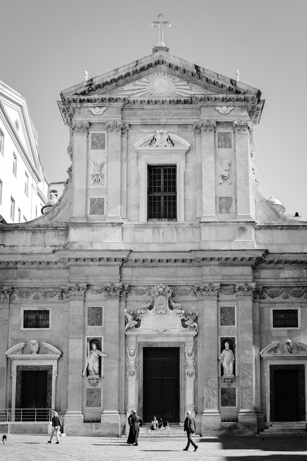 a black and white photo of people walking in front of a church