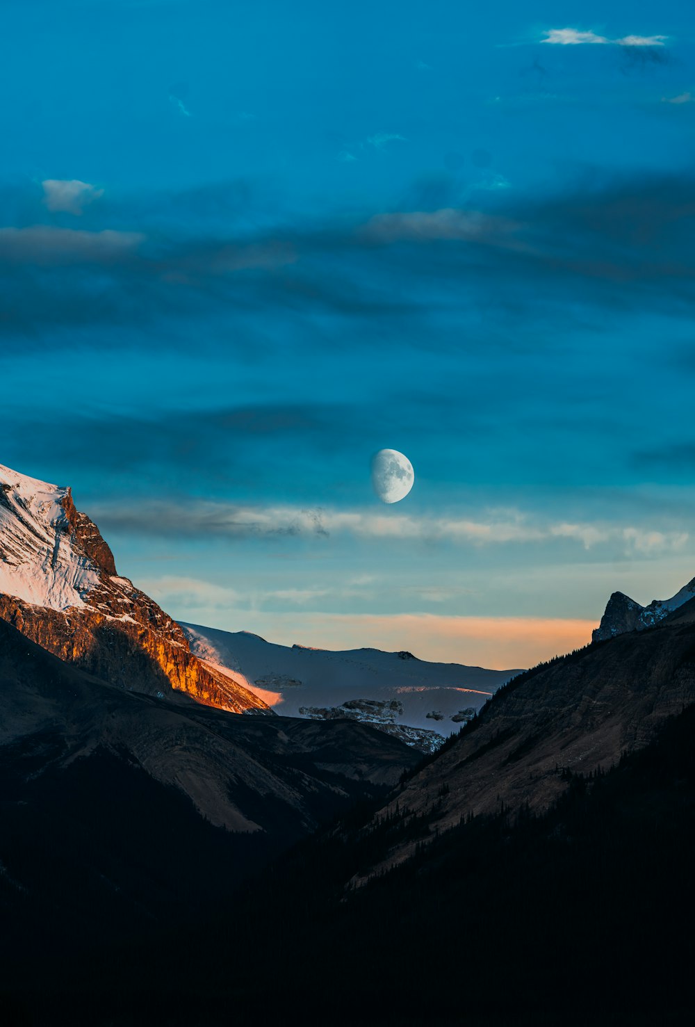 a mountain with a moon in the sky