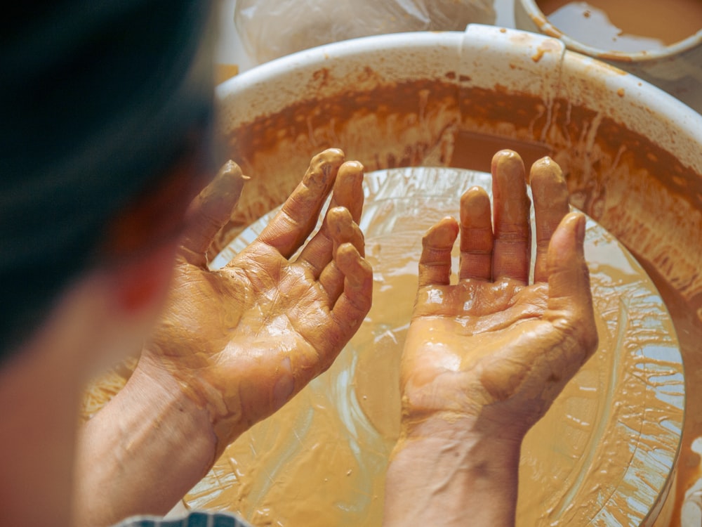 a person washing their hands in a tub of water